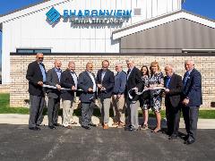 image of Sharonview staff and board of directors cutting ribbon at ceremony